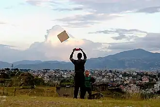 A man flying a kite, seen from behind