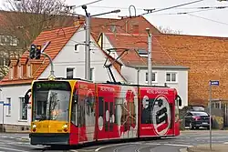 Three-section tram in red advertising livery. The destination display shows "5 Nordhausen Ost".