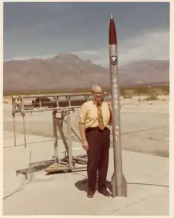 ASL researcher poses next to a Quanah meteorological rocket.