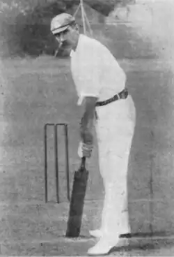A black and white picture of a cricketer holding a cricket bat
