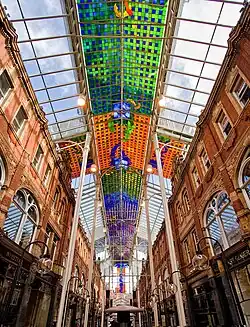 The abstract stained glass ceiling of the Victoria Quarter, Leeds (1990) by Brian Clarke, which spans the 400 foot length of the street to form a covered arcade[47]