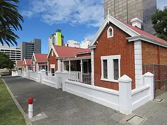 Red brick cottages with white fences in front