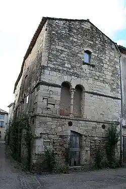 House in Villemagne-l'Argentiere, France, with carved details on doors and windows.