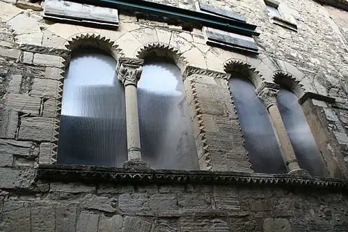 Details of the windows of a former mint in Villemagne l'Argentiere, France, showing chevroning and carved capitals.
