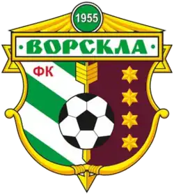 A logo having a football in the middle, writing at the top, above it the number 1955, a diagonally green and white striped left side and dark red side with four stars on the left. The logo has a golden frame.