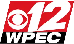 Two slanted boxes, one red and one thinner and black. In the red box, a white CBS eye and a skewed numeral 12. In the black box, the letters W P E C in an extended sans serif in white.