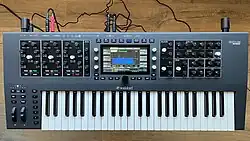 A top-down picture of the Waldorf Iridium Keyboard synthesizer, turned on, with a latched chord playing. The screen shows the filter configuration screen.