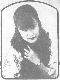 A black-and-white image of a woman wearing a boa