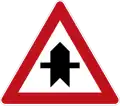 Dangerous intersection with priority indication (for the next intersection only). Different variants of the sign can be used on both priority- and non-priority roads. Each sign has the thicker line indicating the road or direction that has priority with the viewer's own direction being from the bottom of the sign.
