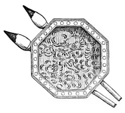 A doorpull: its design represents an octagonal inkstone and two brushes lying slightly splayed across "underneath" it, — the brushes being silvered and tipped with lacquer (as if dipped in ink), while the recessed octagonal portion is engraved with a dragon.