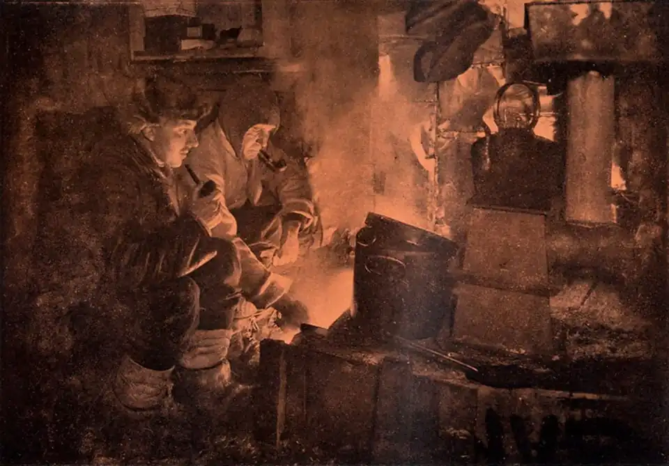 Photo of two seated men smoking pipes in a utilitarian corner