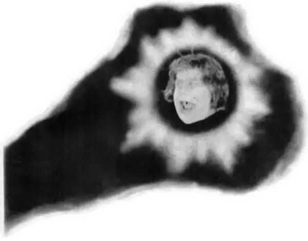 A ghostly face appears surrounded by shining light