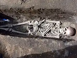 Colour photograph of a human skeleton in an excavated Icelandic grave.