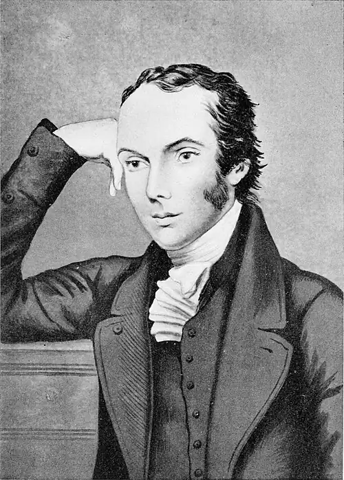 Black and white bust-length portrait of a man in a Victorian suit, facing left.