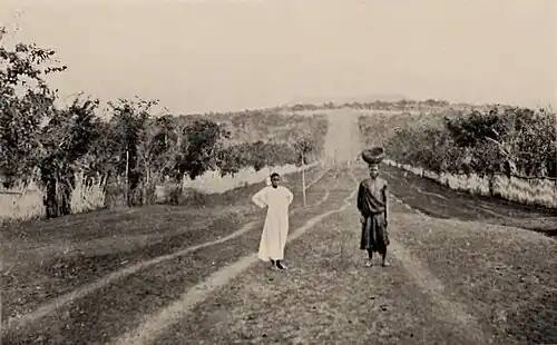 Two persons on a large dirt road